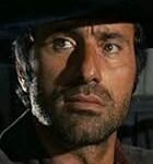 Primer plano de Raf Baldassarre con sombrero negro en una escena de western