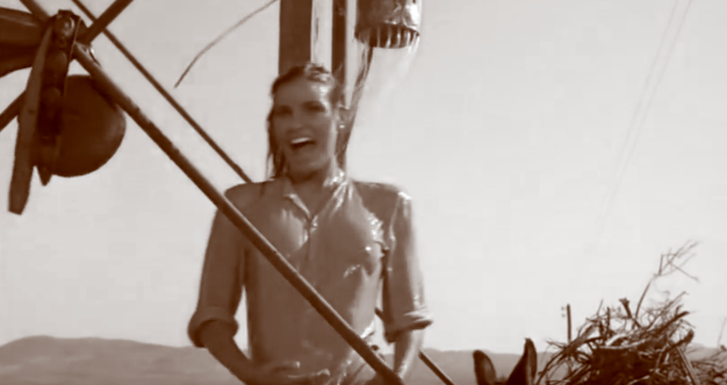 Raquel Welch riendo mientras se ducha vestida bajo un cubo de agua, en una escena en sepia de la película Cien Rifles, rodada parcialmente en Villamanta